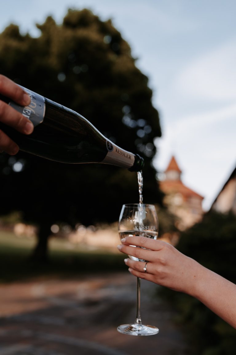 Der Champagner wird in ein Weinglas gegossen.