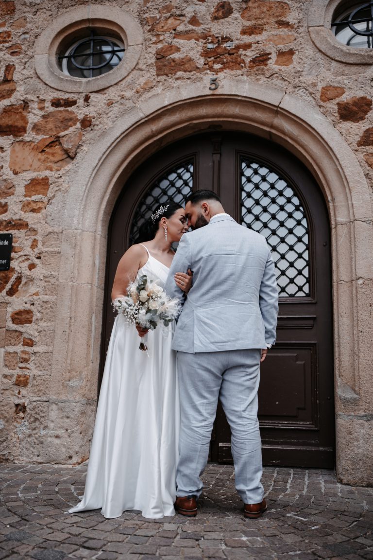 Brautpaar vor einem Tor.