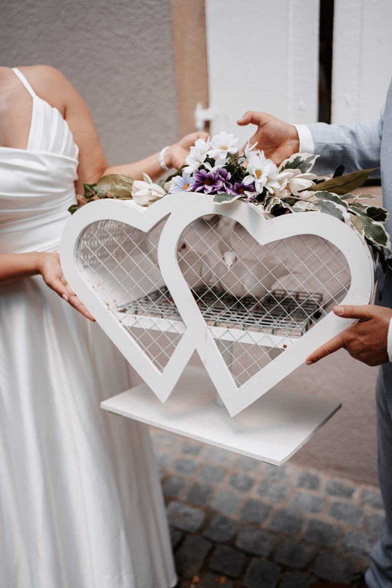 Brautpaar hält zwei schöne Herzen in weiss.