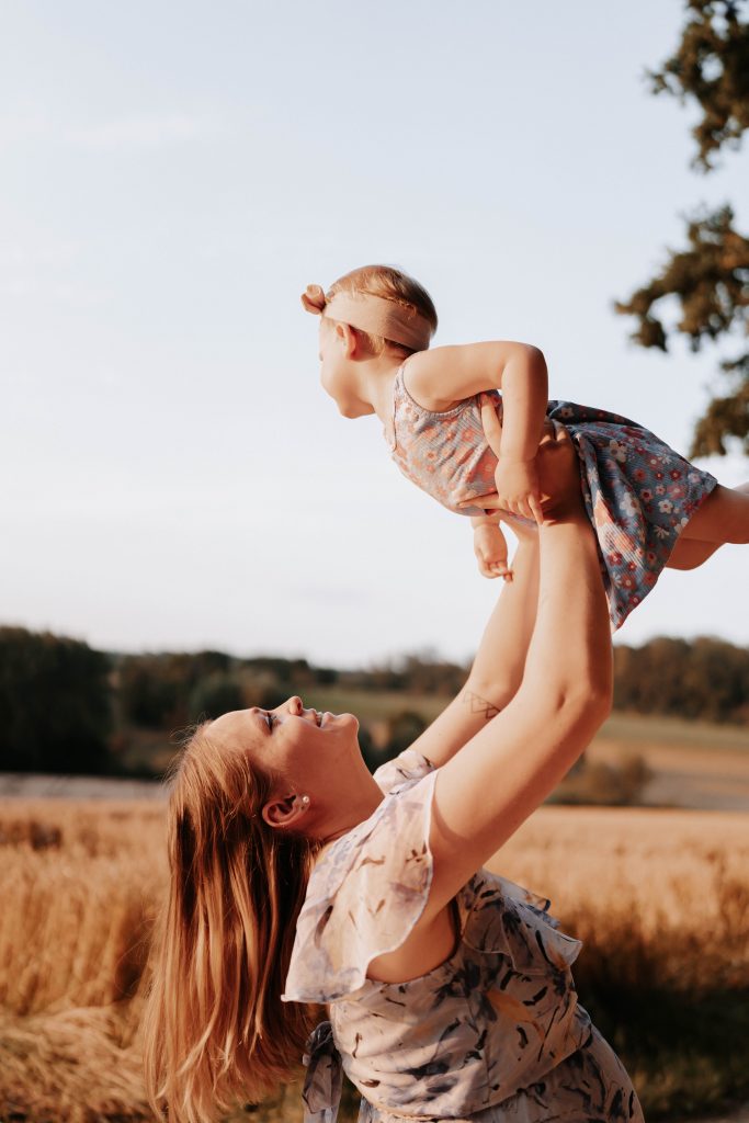 Mutter hält ihr Kind hoch in die Luft.
