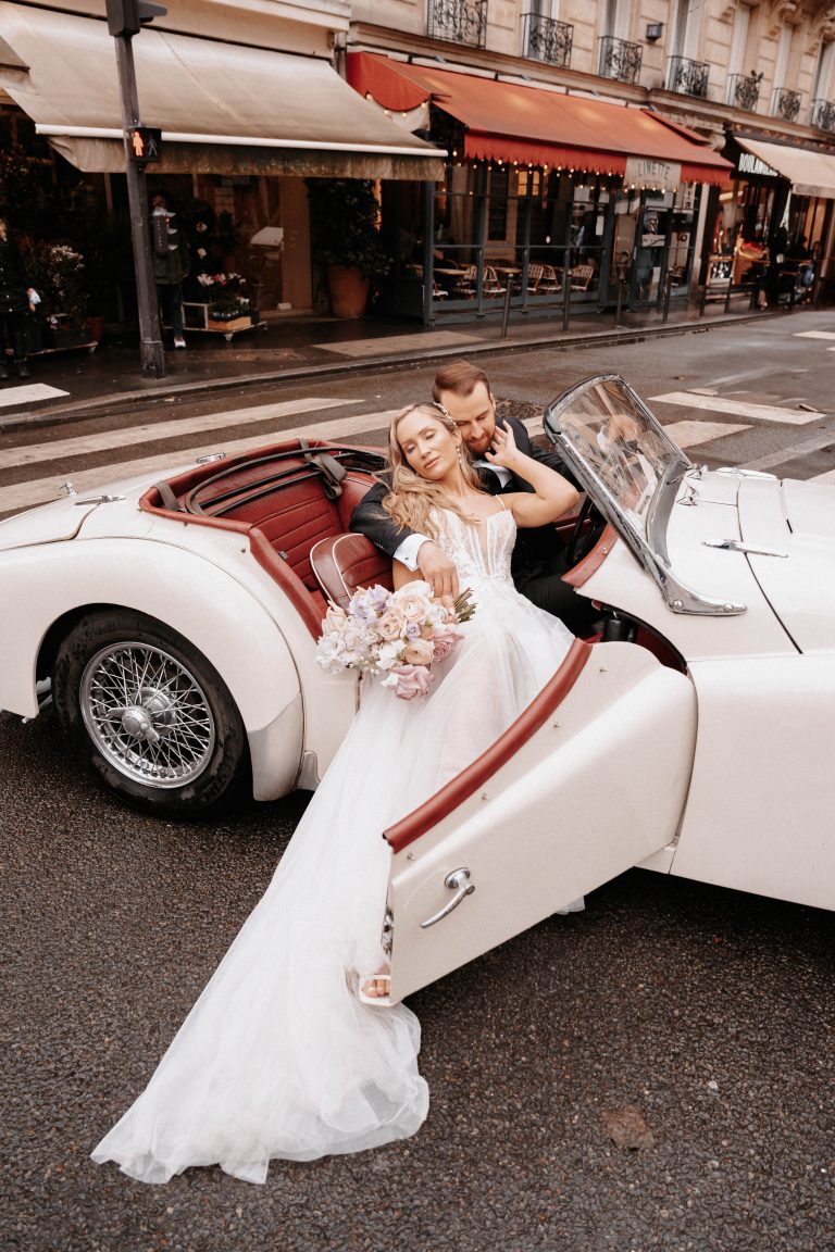 Brautpaar in einem weissen Cabrio.